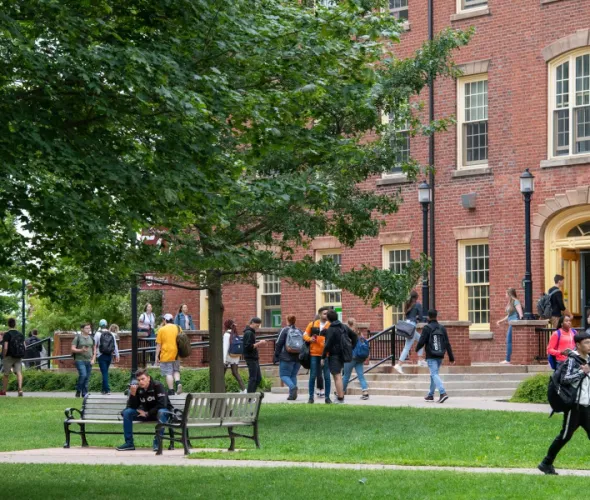 Photo of students walking and entering building on campus